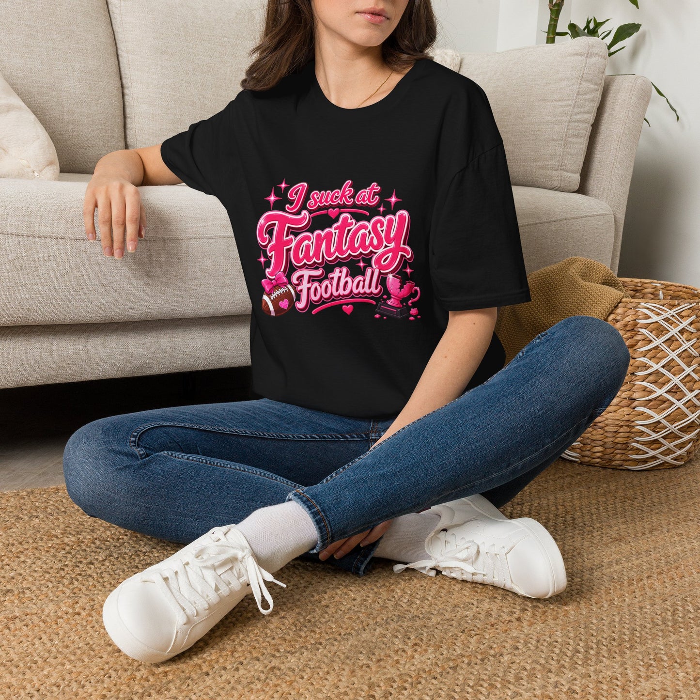 Black Gildan 64000 Softstyle t-shirt with a glossy pink script print reading I suck at Fantasy Football across the chest, with hearts, a football tied with a pink bow, and a shattered pink trophy.