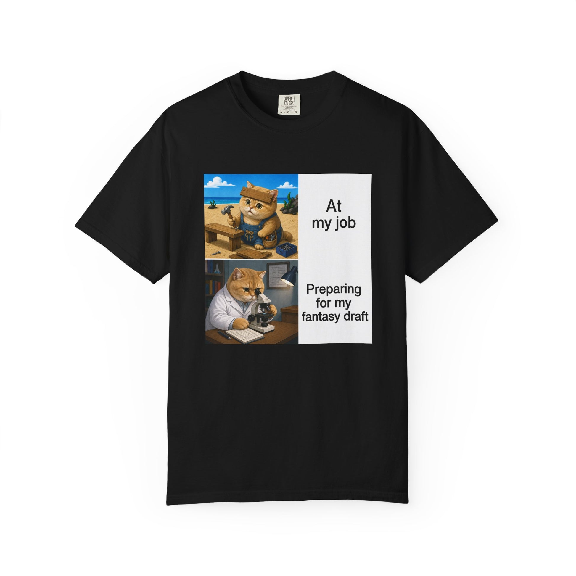 Black Comfort Colors 1717 t-shirt with a square two-panel print on an off-white card across the chest: an orange cat in denim overalls hammering a nail into a wooden bench on a beach, captioned At my job, above the same cat in a white lab coat hunched over a microscope beside a notebook of stats, captioned Preparing for my fantasy draft.