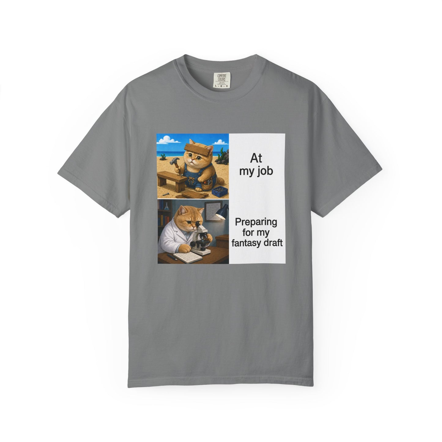 Grey Comfort Colors 1717 t-shirt with a square two-panel print on an off-white card across the chest: an orange cat in denim overalls hammering a nail into a wooden bench on a beach, captioned At my job, above the same cat in a white lab coat hunched over a microscope beside a notebook of stats, captioned Preparing for my fantasy draft.