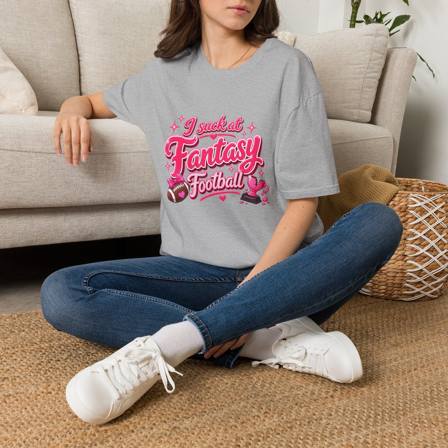 Sport Grey Gildan 64000 Softstyle t-shirt with a glossy pink script print reading I suck at Fantasy Football across the chest, with hearts, a football tied with a pink bow, and a shattered pink trophy.