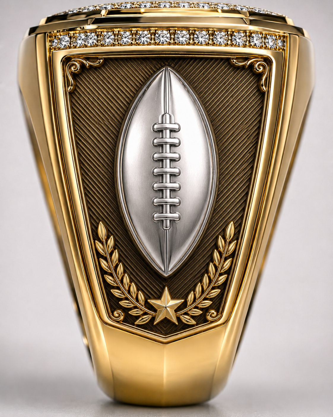 Custom League Champion Ring, shoulder view. A silver football sits over a textured gold shield with laurel and star detail.